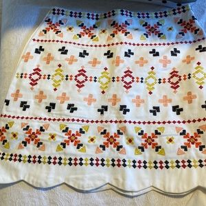 Scalloped white embroidered skirt.